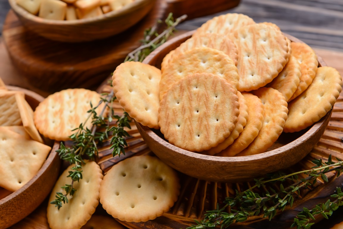 Bowl,With,Crackers,On,Wooden,Background